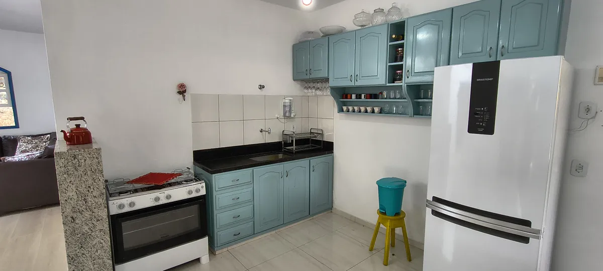 Cozinha completa com fogão, geladeira e armários em estilo colonial azul no Sítio Canto da Seriema